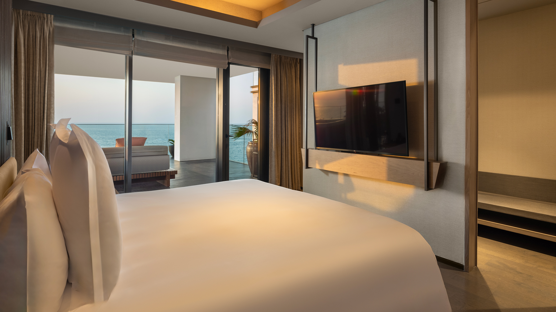 Bed facing TV, balcony view, ocean horizon; Banyan Tree Dubai harmony 3-bedroom oceanfront royal suite elegance.